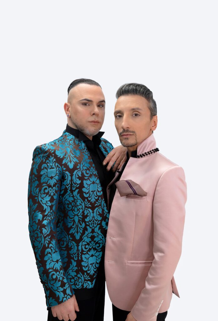 Martin Maldonado and Maurizio Ghella standing together in brocade and pink jackets, pale ground.
