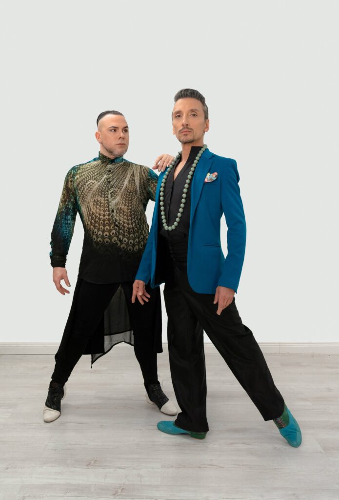 Martin Maldonado and Maurizio Ghella side by side mid-step on a pale studio ground.